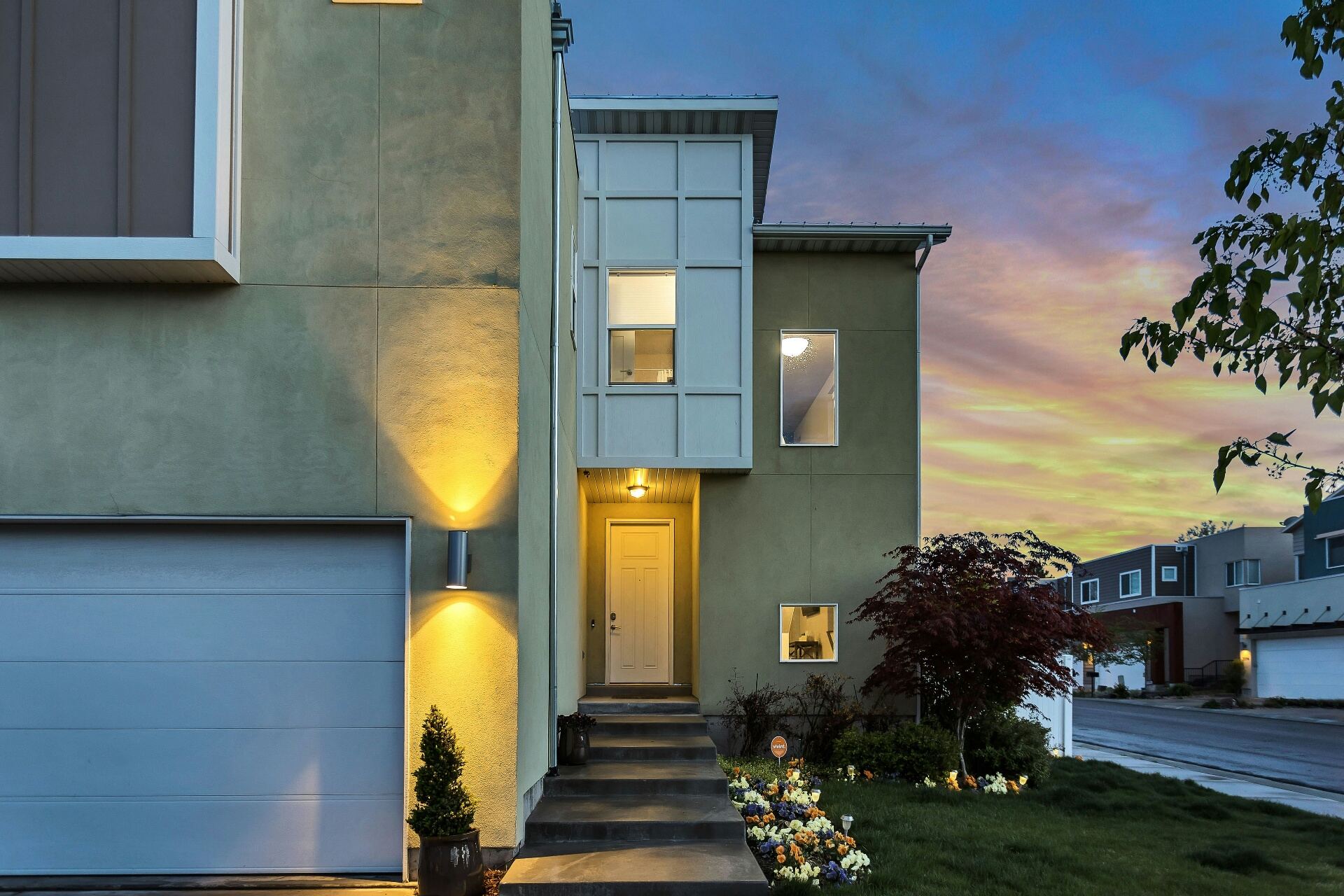 Modern home exterior at dusk with warm entry lighting — representing NPM's hands-on real estate project management